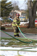 Firefighter in gear running a hose