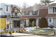 Firefighters and Fire Engine in front of a Smoking House