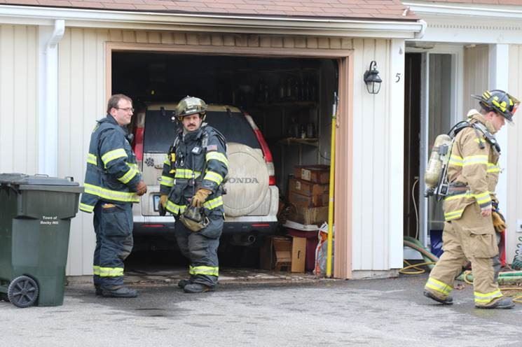 Firefighters in gear at the site of a house fire