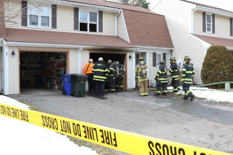 Firefighters in Front of House with Fire Line Caution Tape