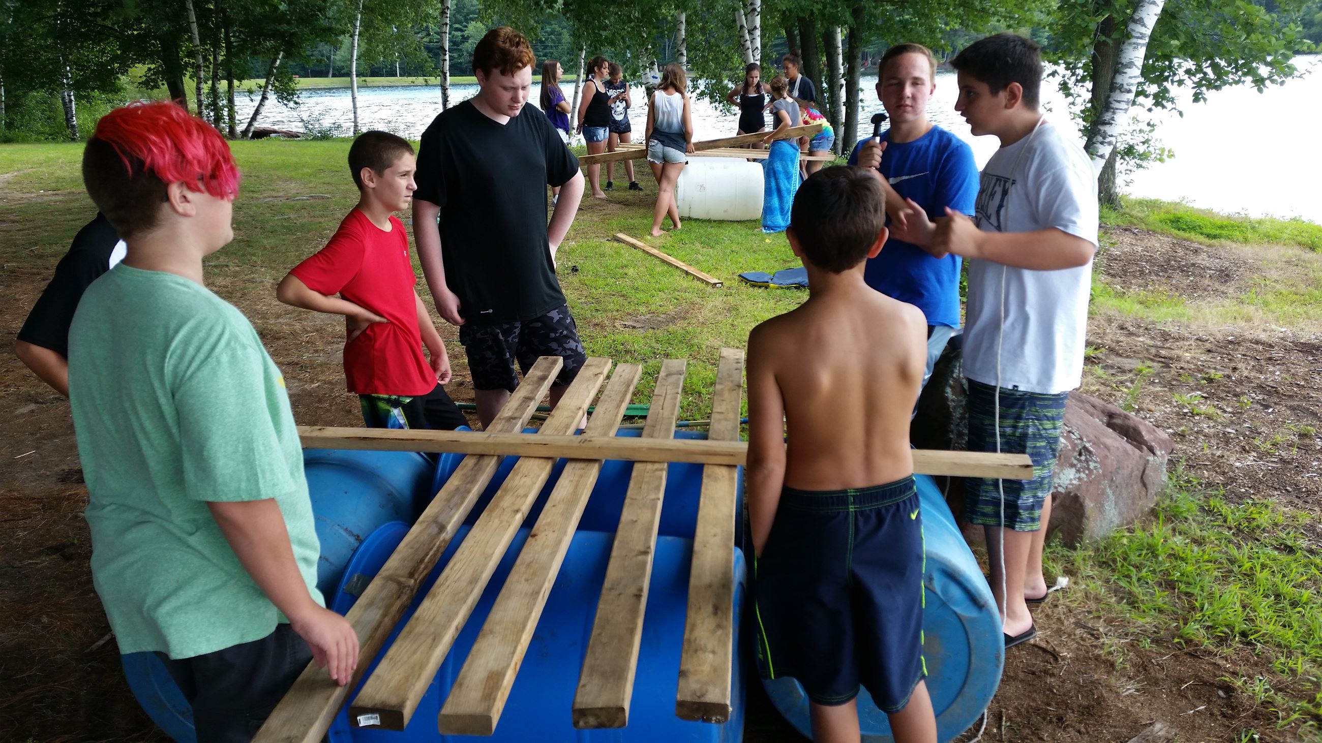 Youths and mentor talking near a body of water